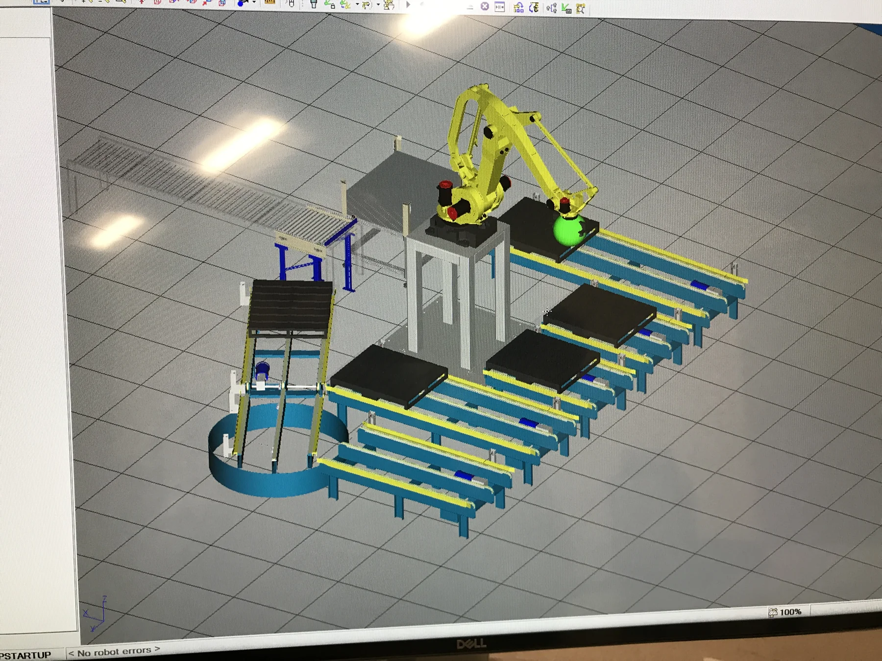 Workstation photograph showing a robot, conveyors, and guarding in a prior cell simulation